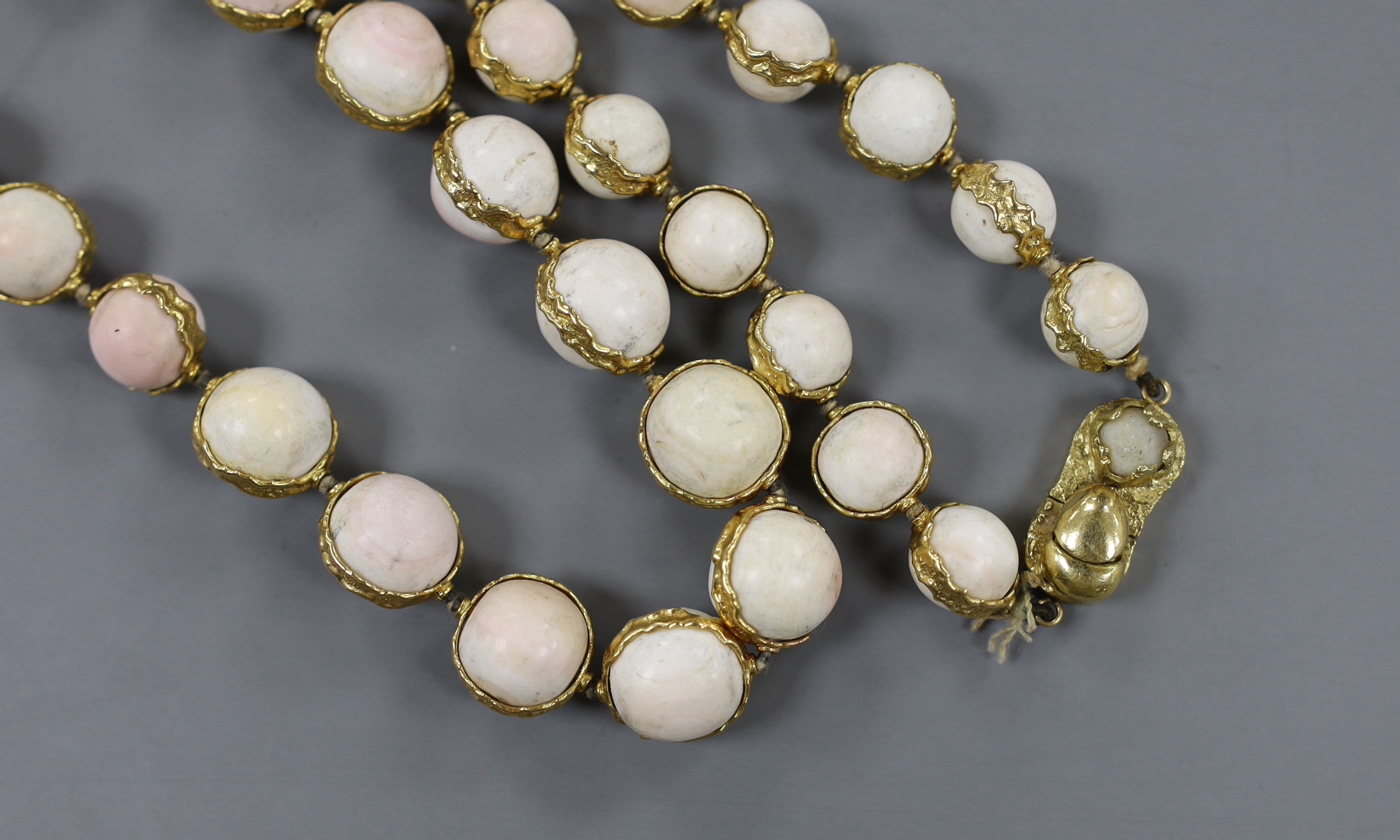 A modern 18ct gold and graduated white coral bead set single strand necklace, with 18ct gold clasp, 99cm, gross weight 212 grams.